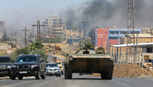 Membros das forças de segurança da Síria atravessam a cidade predominantemente drusa de Sweida em 15 de julho de 2025, enquanto a fumaça sobe após o bombardeio israelense após confrontos entre tribos beduínas e combatentes drusos. Israel lançou ataques em 15 de julho contra as forças do governo sírio na região de maioria drusa de Sweida, alegando estar agindo para proteger a minoria religiosa. (Foto de Bakr ALKASEM / AFP)