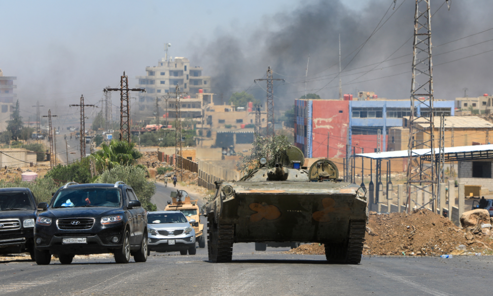Membros das forças de segurança da Síria atravessam a cidade predominantemente drusa de Sweida em 15 de julho de 2025, enquanto a fumaça sobe após o bombardeio israelense após confrontos entre tribos beduínas e combatentes drusos. Israel lançou ataques em 15 de julho contra as forças do governo sírio na região de maioria drusa de Sweida, alegando estar agindo para proteger a minoria religiosa. (Foto de Bakr ALKASEM / AFP)