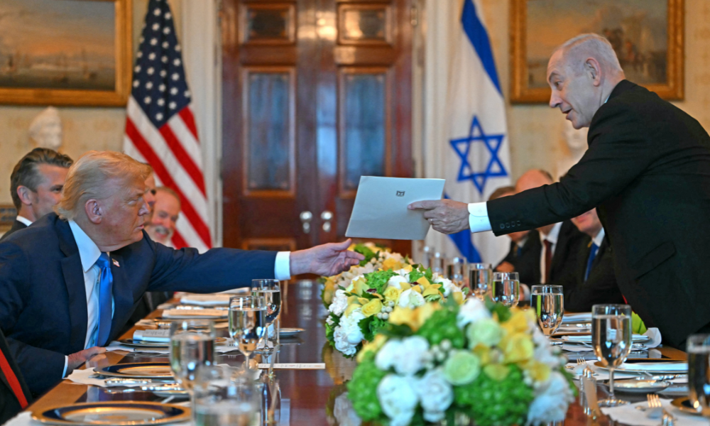 O primeiro-ministro israelense, Benjamin Netanyahu (à direita), entrega uma carta ao presidente dos EUA, Donald Trump, durante encontro no Salão Azul da Casa Branca, em Washington, D.C., em 7 de julho de 2025. O primeiro-ministro Netanyahu se reunirá na segunda-feira com o presidente Trump, que expressou a esperança de um "acordo esta semana" entre Israel e o Hamas para a libertação de reféns da Faixa de Gaza. As negociações indiretas entre Israel e o Hamas começaram em 6 de julho em Doha, com o objetivo de mediar um cessar-fogo e chegar a um acordo sobre a libertação de reféns em troca de prisioneiros palestinos. (Foto de ANDREW CABALLERO-REYNOLDS / AFP)