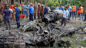 IMAGEM PRINCIPAL - O corpo de bombeiros e a equipe de segurança de Bangladesh realizam uma operação de busca e salvamento após um jato de treinamento da Força Aérea ter caído em uma escola em Daca, em 21 de julho de 2025. Um caça de treinamento de Bangladesh caiu em uma escola na capital, Daca, em 21 de julho, matando pelo menos 19 pessoas e ferindo dezenas no acidente de aviação mais mortal do país em décadas. (Foto de Jubair Bin IQBAL / AFP)