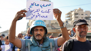 FOTOGRAFIA PRINCIPAL - Um manifestante segura uma placa com os dizeres em árabe "um jornalista faminto escreve uma reportagem sobre os famintos" durante um protesto de jornalistas contra a fome no distrito de Rimal, na Cidade de Gaza, em 19 de julho de 2025. (Foto de Omar AL-QATTAA / AFP)