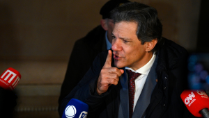 O ministro da Economia do Brasil, Fernando Haddad, fala com a imprensa em frente à casa do embaixador brasileiro em Buenos Aires, em 2 de julho de 2025, durante a 66ª Cúpula de Líderes do Mercosul e Estados Associados. Líderes do bloco sul-americano do Mercosul realizarão dois dias de negociações em Buenos Aires, com foco em um acordo comercial de grande porte com a União Europeia, que está sendo bloqueado pela França. (Foto de LUIS ROBAYO / AFP)