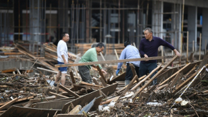 Pessoas limpam a área após uma enchente no condado de Wuqi, na cidade de Yan'an, província de Shaanxi, na China