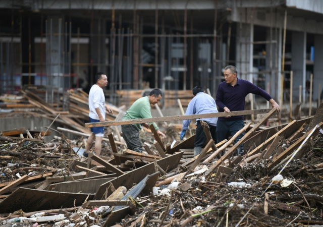 Pessoas limpam a área após uma enchente no condado de Wuqi, na cidade de Yan'an, província de Shaanxi, na China