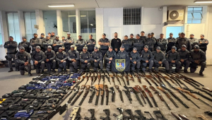 Policiais posam com armas apreendidas, entre fuzis, revólveres, pistolas, carabinas e espingardas