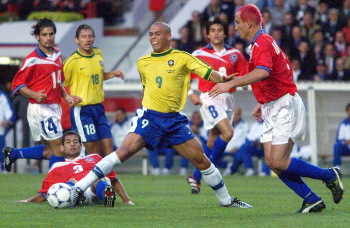 Durante a partida válida pelas oitavas-de-final da Copa do Mundo de 98, entre Brasil e Chile, Ronaldo (9) se estica todo para não perder a bola para Fuentes (3)