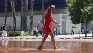 Mulher se refresca em uma fonte em Lisboa