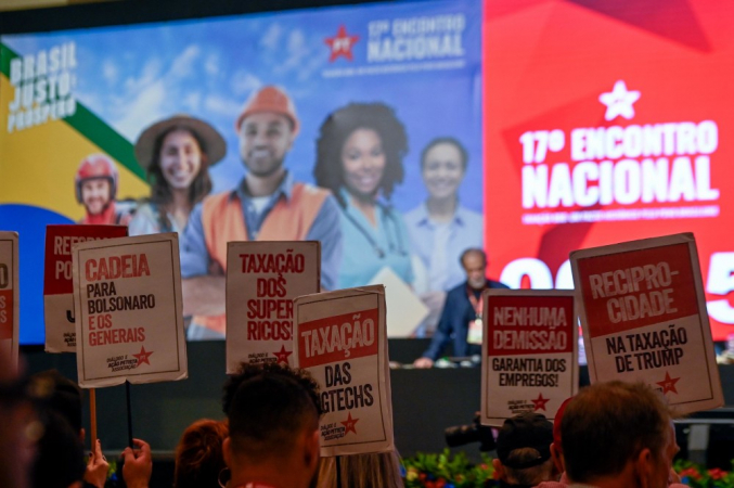 Militante petista levanta placa pedindo "reciprocidade na taxação de Trump" durante o 17º Encontro Nacional do Partido dos Trabalhadores, em Brasília