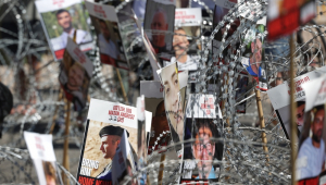 Fotos de reféns israelenses mantidos pelo Hamas em Gaza são colocadas em uma cerca de arame farpado durante manifestação de familiares durante manifestação em Tel Aviv