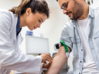 Amigável flebotomista do hospital coletando amostra de sangue do paciente
