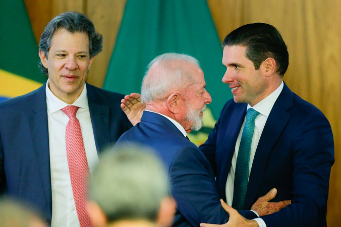 o ministro da Fazenda, Fernando Haddad, o presidente da República, Luiz Inácio Lula da Silva, e o presidente da Câmara dos Deputados, Hugo Motta, durante cerimônia de assinatura da "Medida Provisória Brasil Soberano", que traz um conjunto inicial de ações para proteger empresas e trabalhadores brasileiros dos efeitos da sobretaxa imposta pelo governo dos Estados Unidos