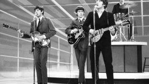 Paul McCartney, George Harrison, John Lennon, e Ringo Starr, se apresentam em programa televisivo na Inglaterra.