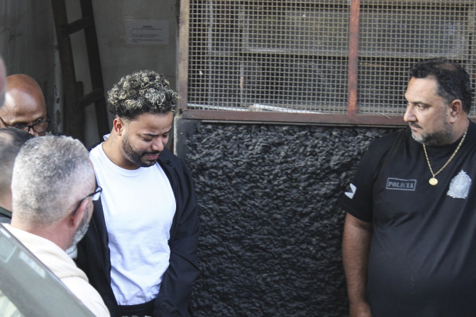 O influenciador Hytalo Santos (de branco) e seu marido Israel Nata Vicente (fora da foto), conhecido como MC Euro, são transferidos do Distrito Policial de Carapicuíba, na Grande São Paulo, para o Centro de Detenção Provisória de Pinheiros