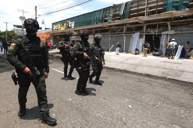 Integrantes dos Grupos Operacionais Especiais de Segurança (GOES) fazem a guarda de estabelecimentos comerciais afetados pela explosão, nesta sexta-feira, em Cali