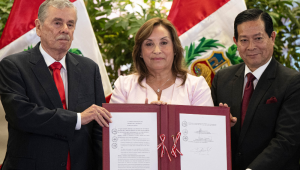 A presidente do Peru, Dina Boluarte (C), mostra o documento assinado ao lado do presidente do Gabinete, Eduardo Arana (D), e do vice-presidente do Congresso, Fernando Rospigliosi (E), durante uma cerimônia de promulgação de uma lei de anistia para militares e policiais processados por violações de direitos humanos no Palácio do Governo em Lima, em 13 de agosto de 2025. A presidente peruana, Dina Boluarte, promulgou na quarta-feira uma polêmica lei de anistia para militares e policiais processados por violações de direitos humanos durante o conflito armado que devastou o país entre 1980 e 2000. (Foto de Ernesto BENAVIDES / AFP)