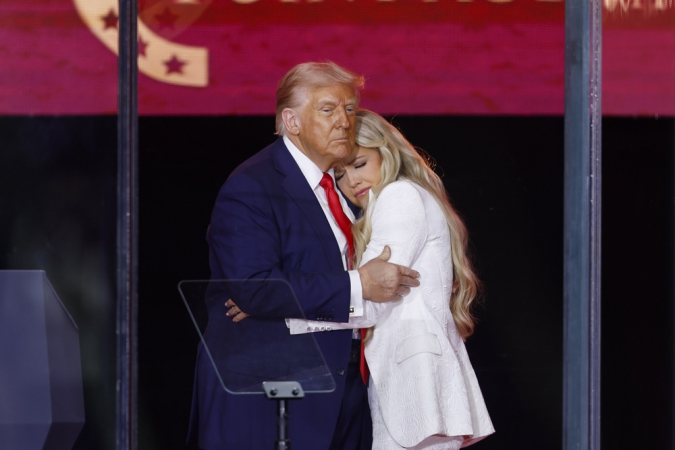 O presidente norte-americano Donald Trump (esq.) abraça Erika Kirk (dir.), viúva de Charlie Kirk, durante homenagem ao ativista no estádio State Farm, no Arizona