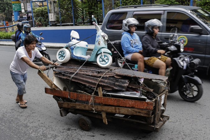 Um coletor de itens descartados e materiais de construção empurra um carrinho ao longo de uma estrada na cidade de Mandaluyong, Metro Manila, Filipinas, 30 de setembro de 2025. O Banco Asiático de Desenvolvimento (ADB) reduziu sua previsão de crescimento para as Filipinas de 6% para 5,6% para o ano de 2025 e de 6,1% para 5,7% para o ano de 2026, revelou o relatório Asian Development Outlook (ADO) de setembro de 2025. (Filipinas) EFE/EPA/ROLEX DELA PENA
