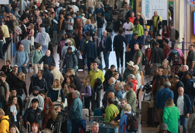 Passageiros fazem fila no aeroporto de Bruxelas, onde dezenas de voos foram cancelados após um ataque cibernético que afetou vários aeroportos na Europa