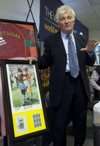Russell Martin, hoteleiro inglês e colecionador apaixonado por memorabilia esportiva, exibe uma de suas peças favoritas — uma ilustração autografada de Pelé, ídolo do futebol brasileiro, e Bobby Moore, lenda da Inglaterra, trocando um aperto de mãos após uma partida