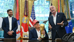 O presidente dos Estados Unidos, Donald Trump, ao lado do vice-presidente JD Vance (E) e do presidente da Fifa, Gianni Infantino (D), segura o troféu da Copa do Mundo