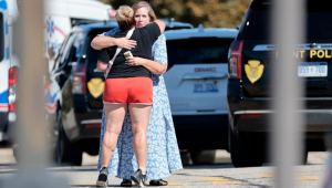 Pessoas se abraçam perto do local de um ataque a tiros em uma igreja em Grand Blanc, Michigan