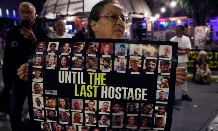 Parentes de reféns israelenses levantam fotos durante um protesto pedindo ações para a libertação de reféns israelenses