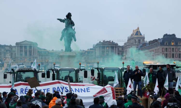TOPSHOT - Chefe do principal sindicato de agricultores da França, FNSEA (Federation Nationale des syndicats d'exploitants agricoles), Arnaud Rousseau (4ºR), fala com agricultores e ativistas da FNSEA durante um protesto contra a concorrência desleal e o acordo de livre comércio do Mercosul, na Place d'Armes no Chateau de Versailles em Versalhes, em 26 de setembro de 2025. (Foto de GEOFFROY VAN DER HASSELT/AFP)