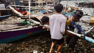 Pescadores protegem um barco de pesca em antecipação à aproximação de uma tempestade na cidade de Cavite, Filipinas, 26 de setembro de 225. A agência meteorológica do estado filipino alertou o público para estar em alerta contra inundações, deslizamentos de terra e tempestades enquanto a tempestade tropical severa Bualoi avança em direção ao centro das Filipinas. (Inundações, tormenta, Filipinas) EFE/EPA/FRANCIS R. MALASIG