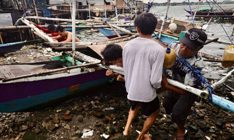 Pescadores protegem um barco de pesca em antecipação à aproximação de uma tempestade na cidade de Cavite, Filipinas, 26 de setembro de 225. A agência meteorológica do estado filipino alertou o público para estar em alerta contra inundações, deslizamentos de terra e tempestades enquanto a tempestade tropical severa Bualoi avança em direção ao centro das Filipinas. (Inundações, tormenta, Filipinas) EFE/EPA/FRANCIS R. MALASIG