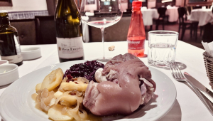 Ptrato alemão na mesa de restaurante acompanhado de garrafa de vinho