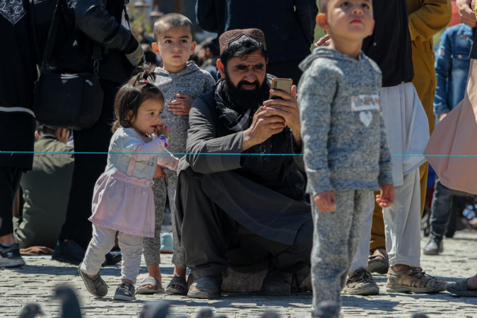 Um homem usa seu celular enquanto crianças ficam por perto após o restabelecimento dos serviços de internet em Cabul, Afeganistão, em 2 de outubro de 2025. O Afeganistão restaurou as redes móveis e a internet em 1º de outubro, após um lockdown nacional de dois dias ordenado pelas autoridades do Talibã. O apagão interrompeu negócios, bancos e viagens, deixando o país praticamente isolado. A Netblocks chamou isso de uma desconexão deliberada. O retorno da conectividade provocou comemorações nas ruas de Cabul, com moradores comparando o momento a um feriado. (Afeganistão) EFE/EPA/SAMIULLAH POPAL