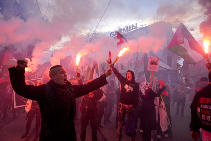 Manifestantes agitam bandeiras palestinas e acendem sinalizadores antes da partida das eliminatórias da Copa do Mundo entre Noruega e Israel, em Oslo