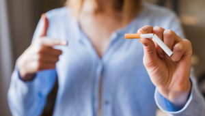 Desfocar mulher apontando para cigarro quebrado