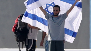 O refém israelense libertado Nimrod Cohen posa com uma bandeira israelense após chegar ao heliporto do Hospital Ichilov em Tel Aviv, Israel, em 13 de outubro de 2025. A primeira fase do acordo de paz de Gaza, firmado entre Israel e o Hamas, inclui a libertação de reféns israelenses e prisioneiros palestinos, uma retirada parcial das forças israelenses e a entrega de ajuda humanitária a Gaza EFE/EPA/ABIR SULTAN