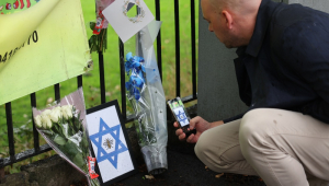 Uma pessoa fotografa flores e homenagens deixadas no local de um ataque terrorista mortal em Manchester, Grã-Bretanha, em 3 de outubro de 2025. Duas pessoas morreram após um ataque com carro e facada em uma sinagoga em Manchester em 2 de outubro, e o agressor, identificado como Jihad Al-Shamie, cidadão britânico de 35 anos, foi morto a tiros pela polícia. (Reino Unido) EFE/EPA/ADAM VAUGHAN