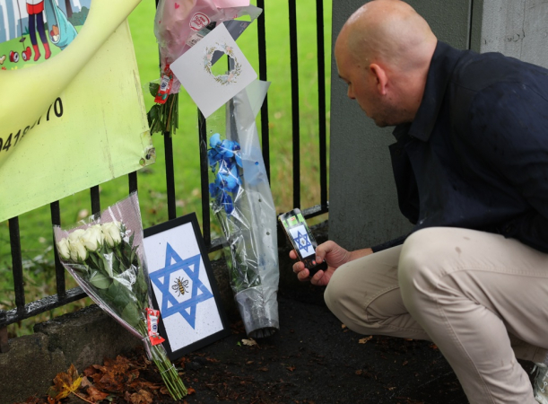 Uma pessoa fotografa flores e homenagens deixadas no local de um ataque terrorista mortal em Manchester, Grã-Bretanha, em 3 de outubro de 2025. Duas pessoas morreram após um ataque com carro e facada em uma sinagoga em Manchester em 2 de outubro, e o agressor, identificado como Jihad Al-Shamie, cidadão britânico de 35 anos, foi morto a tiros pela polícia. (Reino Unido) EFE/EPA/ADAM VAUGHAN