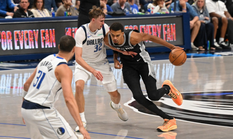 Cooper Flagg, do Dallas Mavericks, defende Victor Wembanyama, do San Antonio Spurs, durante primeira rodada da NBA