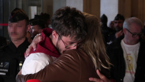 Delphine Daviet, mãe de Lola, e Thibault, irmão de Lola, abraçados enquanto falam com a imprensa do lado de fora do tribunal, em Paris