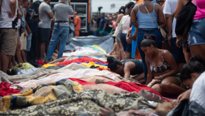 Moradores da comunidade transportam dezenas de corpos para a Praça São Lucas, um dia após a região ter sido palco da operação policial mais letal já registrada no estado