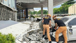 Bombeiros removem detritos do lado de fora de um shopping center após um terremoto na cidade de Butuan, região de Caraga, na Filipinas
