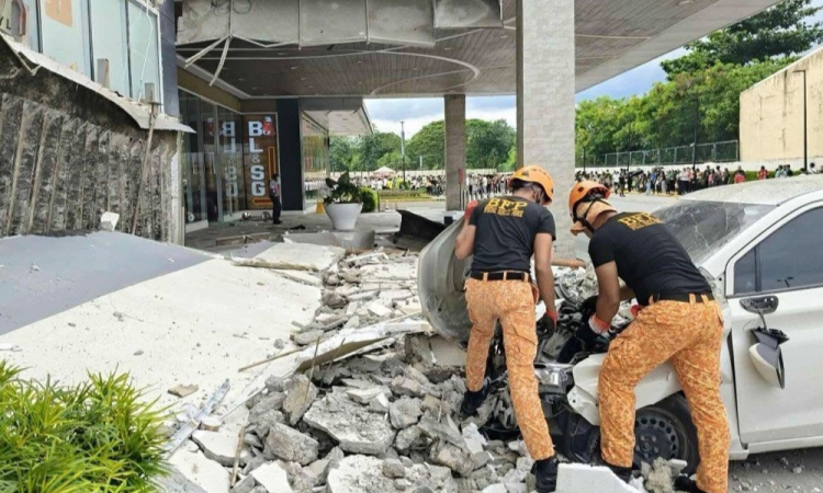 Bombeiros removem detritos do lado de fora de um shopping center após um terremoto na cidade de Butuan, região de Caraga, na Filipinas