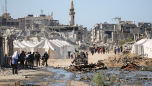 Palestinos deslocados passam por tendas e prédios destruídos enquanto retornam para suas casas, no centro da Faixa de Gaza