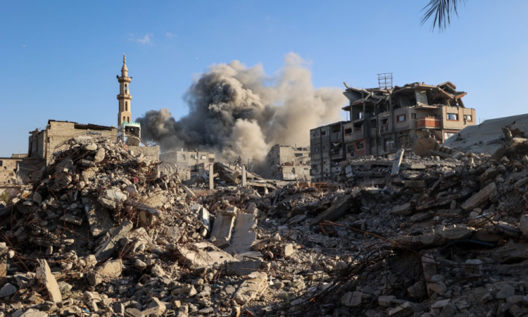 Fumaça sobe após um ataque israelense que teve como alvo um prédio no campo de refugiados palestinos de Bureij, no centro da Faixa de Gaza, neste domingo (19)