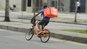 Trabalhador de entrega por aplicativo percorre ruas no centro do Rio de Janeiro