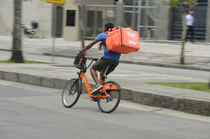Trabalhador de entrega por aplicativo percorre ruas no centro do Rio de Janeiro