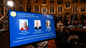 Fotos do físico britânico (da esquerda para a direita) John Clarke na Universidade da Califórnia, EUA, do físico francês Michel H. Devoret (Universidade da Califórnia e Yale) e do físico americano John M. Martinis (Universidade da Califórnia) são vistas em uma tela durante uma coletiva de imprensa sobre a premiação do Prêmio Nobel de Física de 2025 na Real Academia Sueca de Ciências em Estocolmo, Suécia, em 7 de outubro de 2025. John Clarke (Reino Unido), Michel H. Devoret (França) e John M. Martinis (EUA) ganham o Prêmio Nobel de Física de 2025, "pela descoberta do tunelamento mecânico quântico macroscópico e da quantização de energia em um circuito elétrico", foi anunciado em 7 de outubro de 2025. (Foto de Jonathan Nackstrand / AFP)