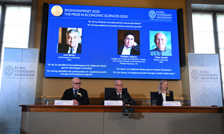 O Prêmio Nobel de Economia foi concedido ao americano-israelense Joel Mokyr, ao francês Philippe Aghion e ao canadense Peter Howitt por seus trabalhos sobre o impacto da tecnologia no crescimento econômico sustentado. Mokyr recebeu metade do prêmio "por ter identificado os pré-requisitos para o crescimento sustentado por meio do progresso tecnológico", enquanto Aghion e Howitt dividiram a outra metade "pela teoria do crescimento sustentado por meio da destruição criativa", afirmou o júri. Uma tela mostra (da esquerda para a direita) o americano-israelense Joel Mokyr, o economista francês Philippe Aghion e o canadense Peter Howitt enquanto o Secretário-Geral da Real Academia Sueca de Ciências, Hans Ellegren (do centro), se dirige a jornalistas, ladeado por membros do comitê do Prêmio Nobel de Economia (da esquerda para a direita) e Kerstin Enflo, durante o anúncio do vencedor do Prêmio Nobel de Economia de 2025, o Prêmio Sveriges Riksbank em Ciências Econômicas em Memória de Alfred Nobel, na Real Academia Sueca de Ciências, em Estocolmo, Suécia, em 13 de outubro de 2025.