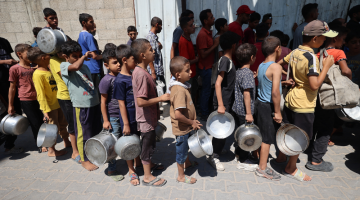 IMAGEM PRINCIPAL - Palestinos fazem fila para receber uma refei&ccedil;&atilde;o quente de uma cozinha beneficente no campo de refugiados de Nuseirat, na Faixa de Gaza sitiada por Israel, em 11 de setembro de 2025, em meio a uma situa&ccedil;&atilde;o de fome declarada pela ONU ap&oacute;s quase dois anos de guerra. (Foto de Eyad BABA / AFP)
