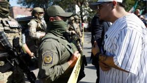 Moradores do bairro de Brighton Park, em Chicago, confrontam agentes da Alfândega e Proteção de Fronteiras dos EUA (CBP) em um posto de gasolina após agentes do Serviço de Imigração e Alfândega (ICE) supostamente deterem um homem não identificado em seu carro, em Chicago, Illinois, em 4 de outubro de 2025. O presidente dos EUA, Donald Trump, que fez campanha prometendo deportar um grande número de migrantes, encorajou as autoridades a serem mais agressivas em sua busca por atingir sua meta amplamente divulgada de um milhão de deportações por ano. (Foto de OCTAVIO JONES / AFP)