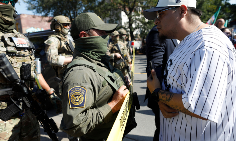 Moradores do bairro de Brighton Park, em Chicago, confrontam agentes da Alfândega e Proteção de Fronteiras dos EUA (CBP) em um posto de gasolina após agentes do Serviço de Imigração e Alfândega (ICE) supostamente deterem um homem não identificado em seu carro, em Chicago, Illinois, em 4 de outubro de 2025. O presidente dos EUA, Donald Trump, que fez campanha prometendo deportar um grande número de migrantes, encorajou as autoridades a serem mais agressivas em sua busca por atingir sua meta amplamente divulgada de um milhão de deportações por ano. (Foto de OCTAVIO JONES / AFP)